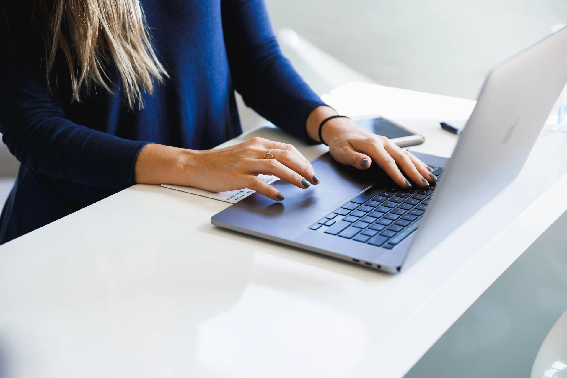Typing on a laptop keyboard at a clean desk setup